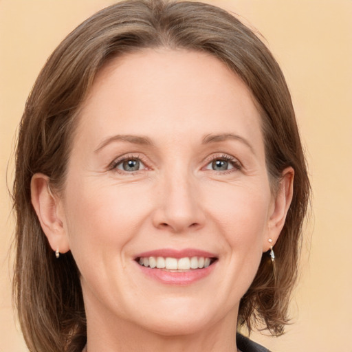 Joyful white adult female with medium  brown hair and grey eyes