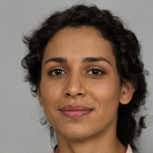 Joyful latino young-adult female with medium  brown hair and brown eyes