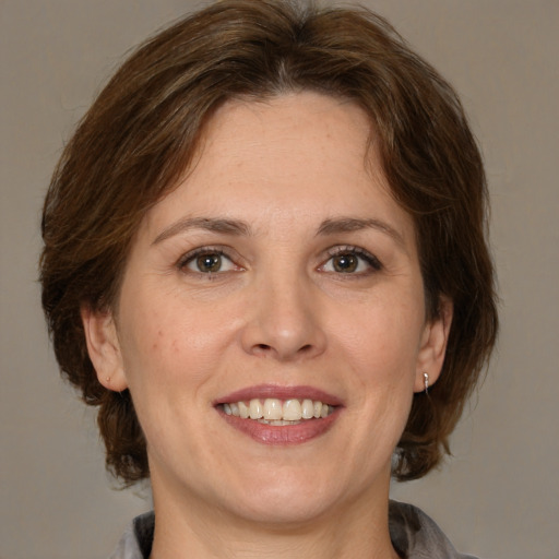 Joyful white adult female with medium  brown hair and grey eyes