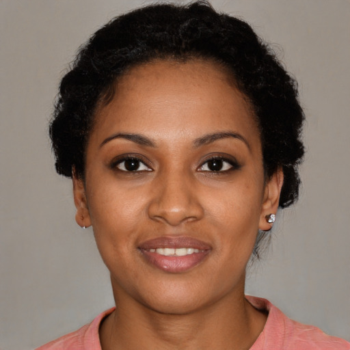 Joyful black young-adult female with short  brown hair and brown eyes