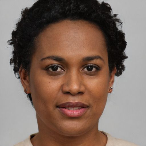 Joyful black young-adult female with short  brown hair and brown eyes