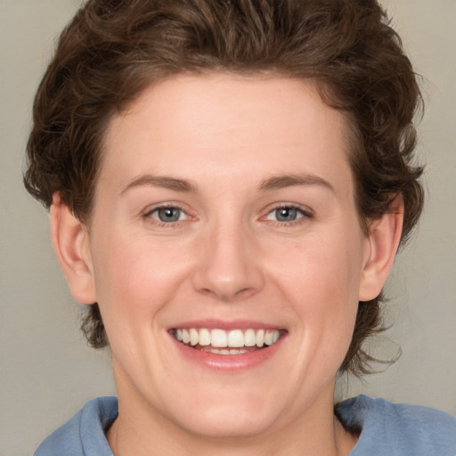 Joyful white young-adult female with medium  brown hair and blue eyes