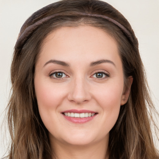 Joyful white young-adult female with long  brown hair and blue eyes