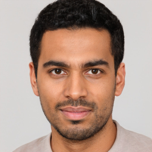 Joyful latino young-adult male with short  black hair and brown eyes