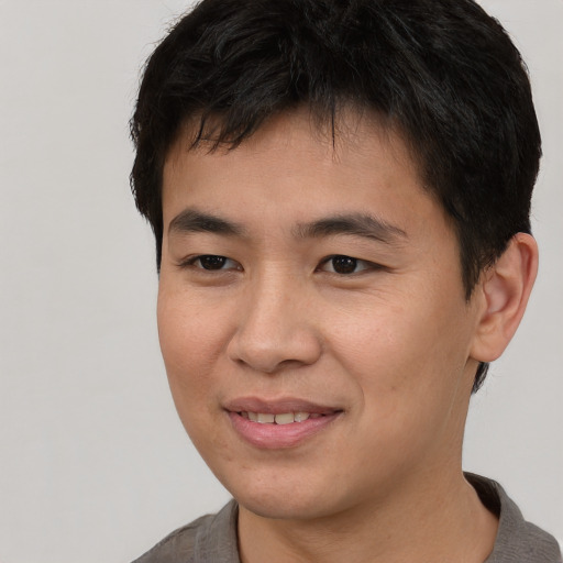 Joyful asian young-adult male with short  brown hair and brown eyes