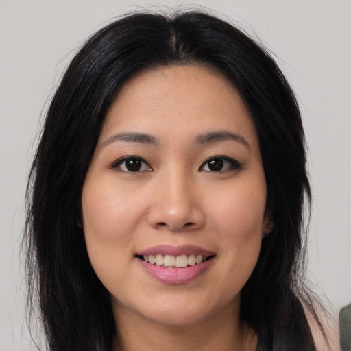 Joyful asian young-adult female with long  black hair and brown eyes