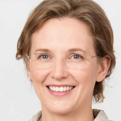 Joyful white adult female with medium  brown hair and grey eyes