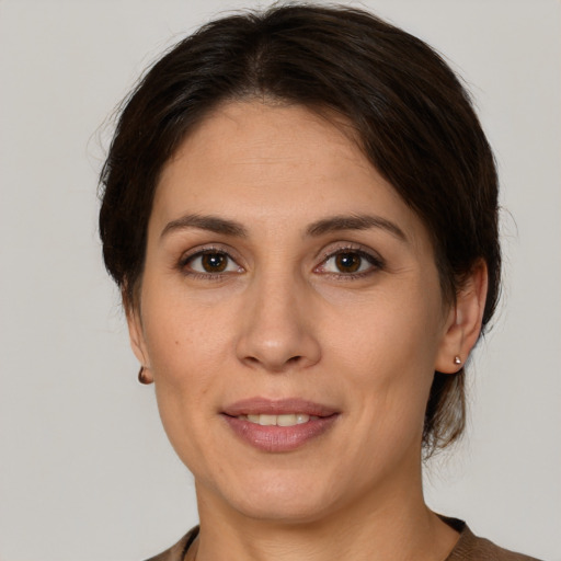 Joyful white adult female with medium  brown hair and brown eyes