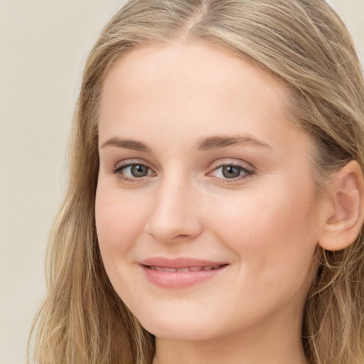 Joyful white young-adult female with long  brown hair and blue eyes