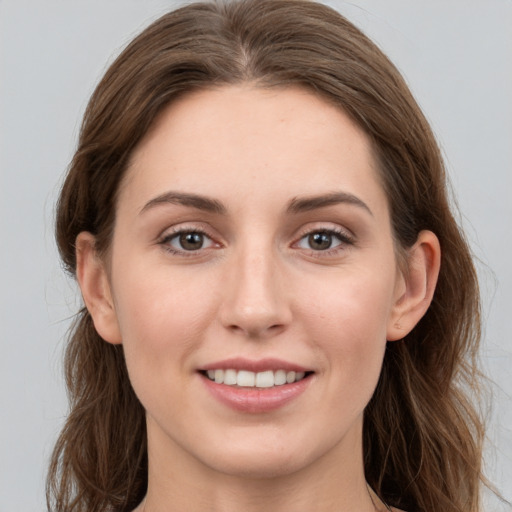 Joyful white young-adult female with long  brown hair and grey eyes