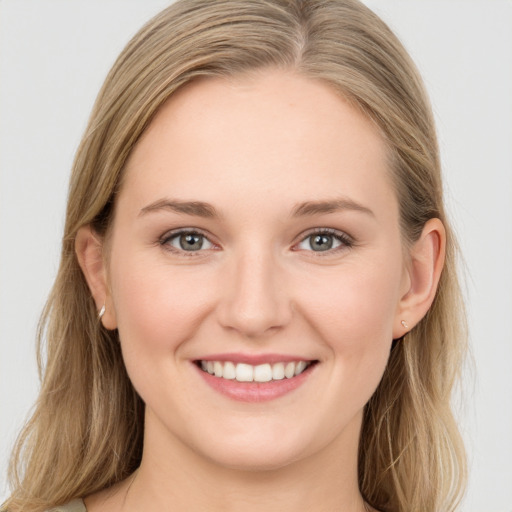 Joyful white young-adult female with long  brown hair and blue eyes