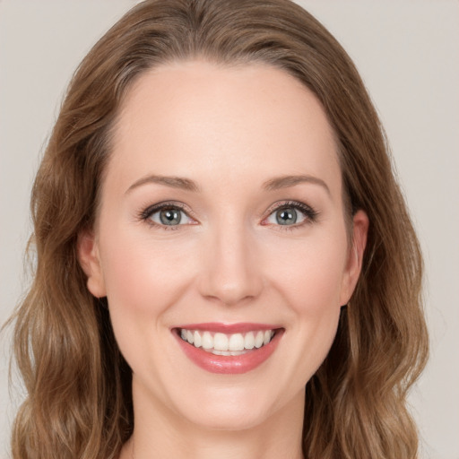 Joyful white young-adult female with medium  brown hair and green eyes