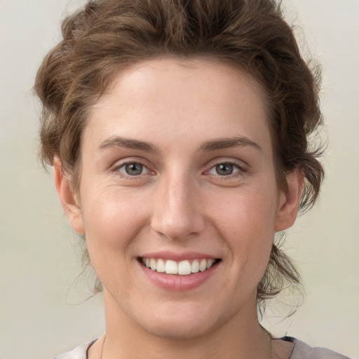 Joyful white young-adult female with short  brown hair and green eyes