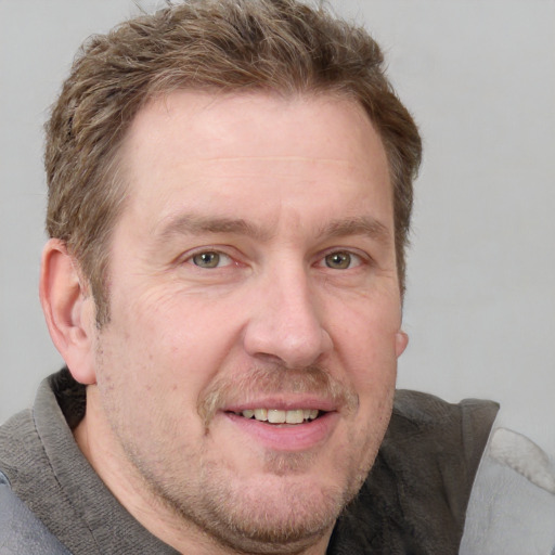 Joyful white adult male with short  brown hair and grey eyes