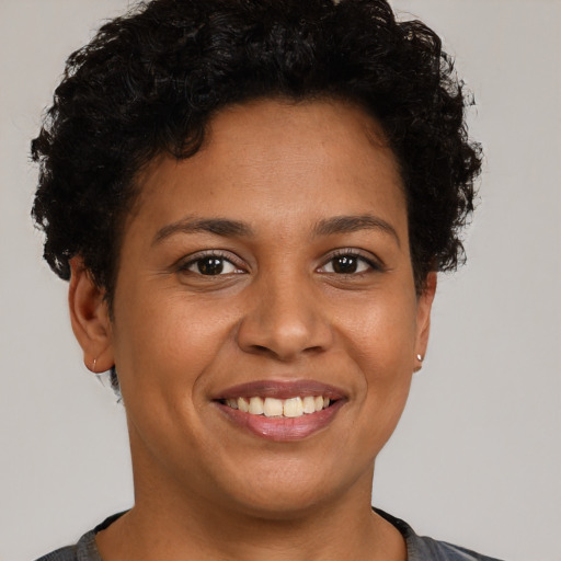 Joyful black young-adult female with short  brown hair and brown eyes