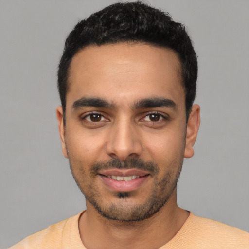 Joyful latino young-adult male with short  black hair and brown eyes