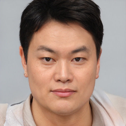 Joyful asian young-adult male with short  brown hair and brown eyes