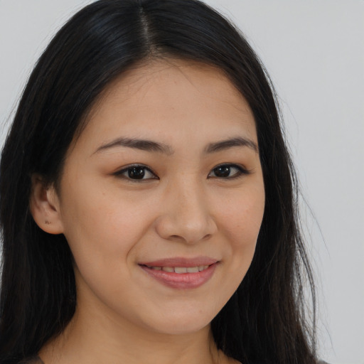 Joyful latino young-adult female with long  brown hair and brown eyes