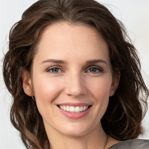 Joyful white young-adult female with medium  brown hair and grey eyes