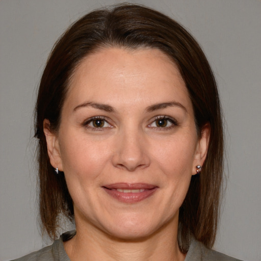 Joyful white adult female with medium  brown hair and brown eyes