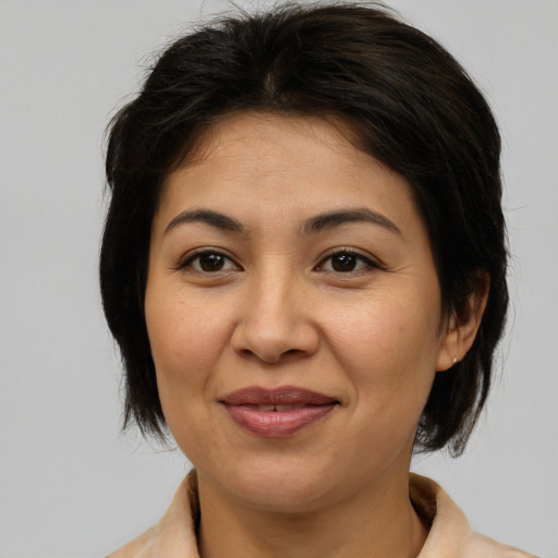 Joyful asian adult female with medium  brown hair and brown eyes