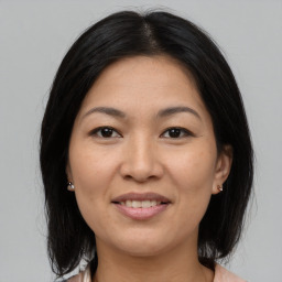 Joyful asian adult female with medium  brown hair and brown eyes