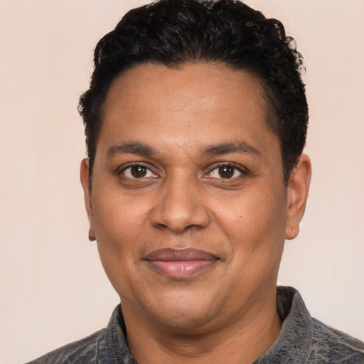 Joyful black adult male with short  black hair and brown eyes