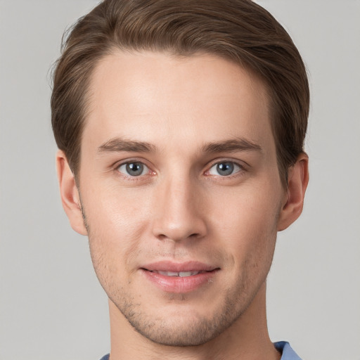 Joyful white young-adult male with short  brown hair and grey eyes