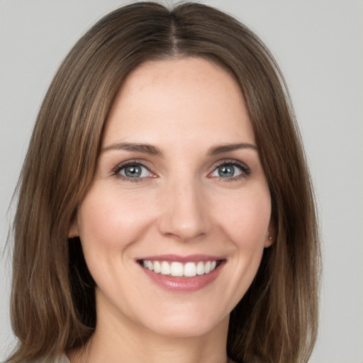 Joyful white young-adult female with long  brown hair and grey eyes