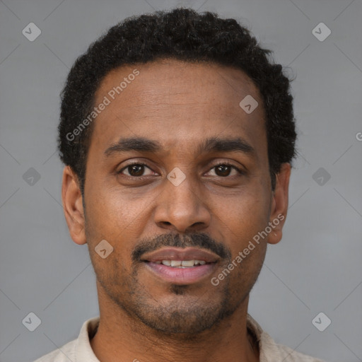 Joyful black young-adult male with short  brown hair and brown eyes