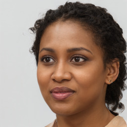 Joyful black young-adult female with long  brown hair and brown eyes