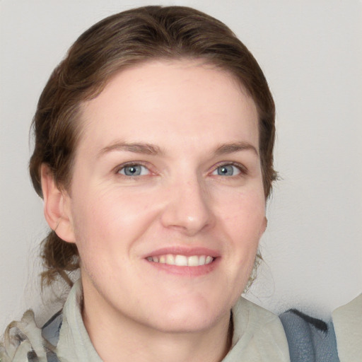 Joyful white young-adult female with medium  brown hair and blue eyes