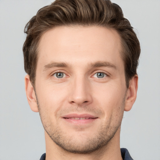 Joyful white young-adult male with short  brown hair and grey eyes