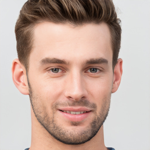 Joyful white young-adult male with short  brown hair and grey eyes