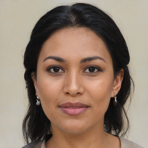 Joyful latino young-adult female with medium  brown hair and brown eyes