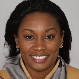 Joyful black adult female with medium  brown hair and brown eyes