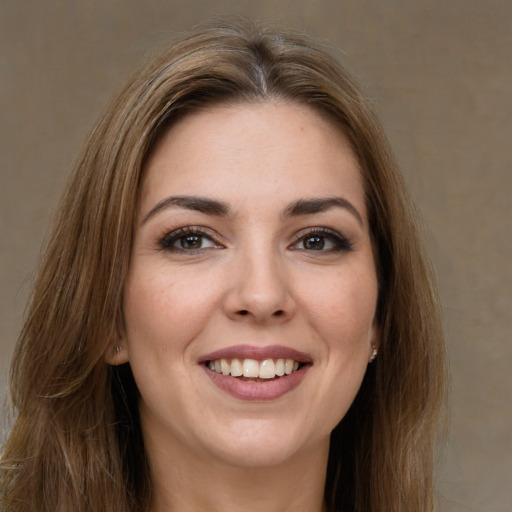 Joyful white young-adult female with long  brown hair and brown eyes