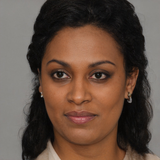 Joyful black young-adult female with long  black hair and brown eyes