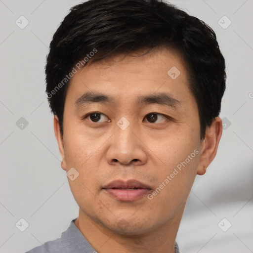 Joyful asian young-adult male with short  black hair and brown eyes