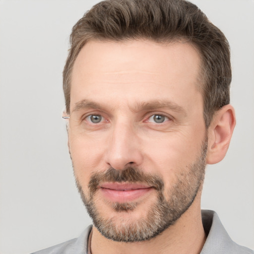 Joyful white adult male with short  brown hair and brown eyes