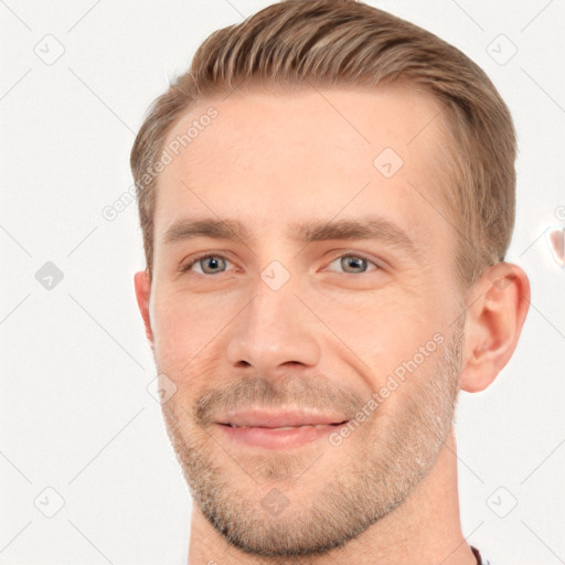 Joyful white young-adult male with short  brown hair and grey eyes