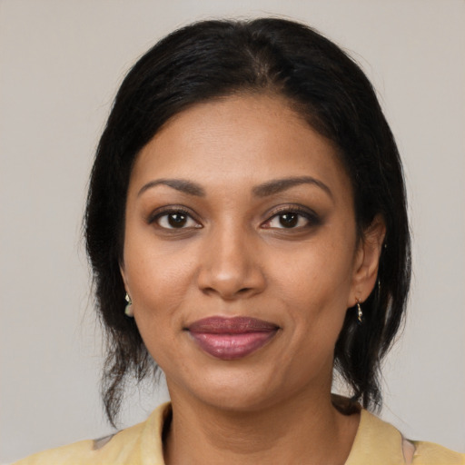 Joyful black young-adult female with medium  brown hair and brown eyes