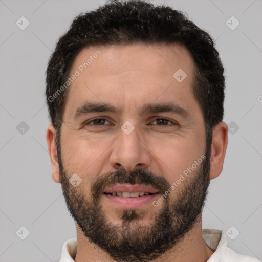 Joyful white adult male with short  black hair and brown eyes