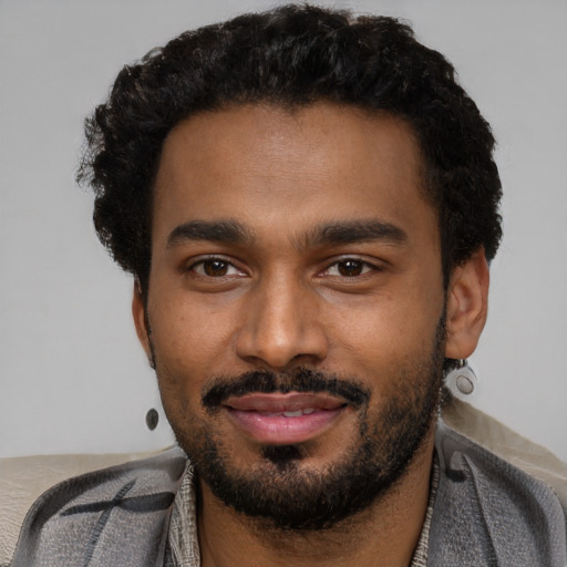Joyful black young-adult male with short  black hair and brown eyes