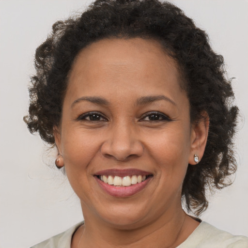 Joyful black adult female with medium  brown hair and brown eyes