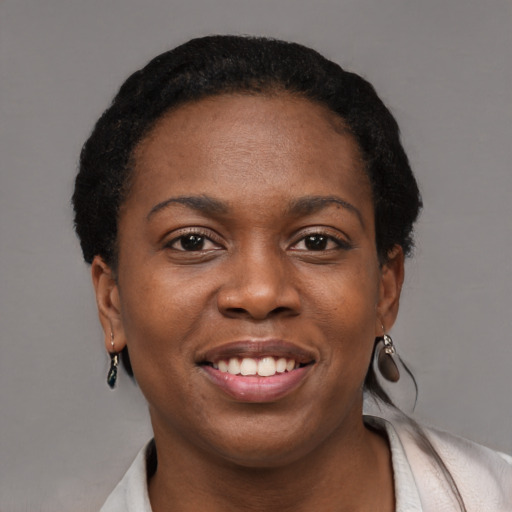Joyful black young-adult female with short  brown hair and brown eyes