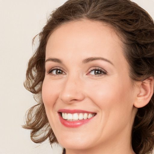 Joyful white young-adult female with medium  brown hair and green eyes