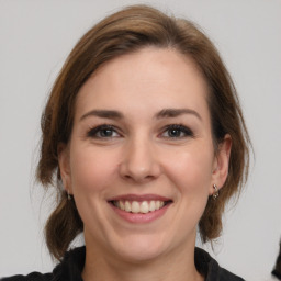 Joyful white young-adult female with medium  brown hair and grey eyes