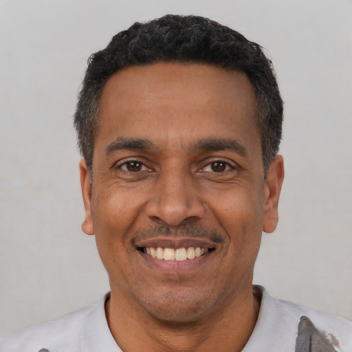 Joyful latino adult male with short  black hair and brown eyes