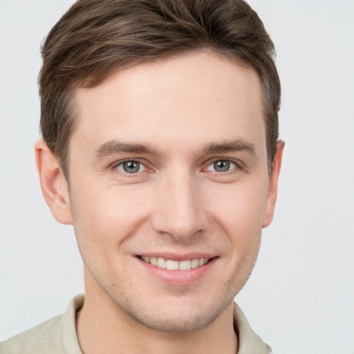 Joyful white young-adult male with short  brown hair and grey eyes